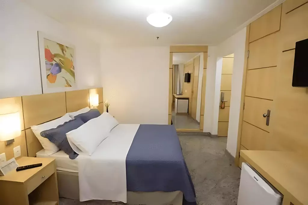 Quarto Confortável e Elegante, cama de casal frigobar, televisão e outros.